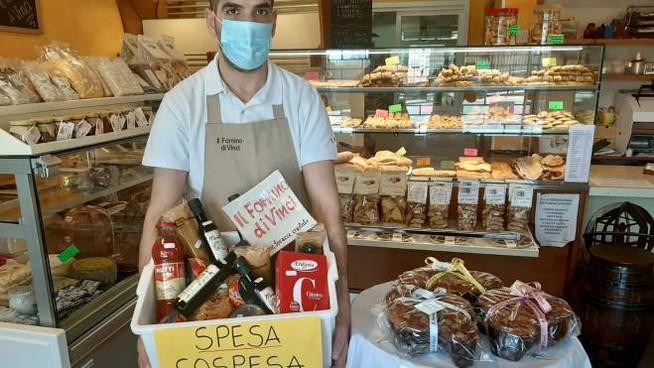 Worker with basket of food for spesa sospesa initiative in Italy