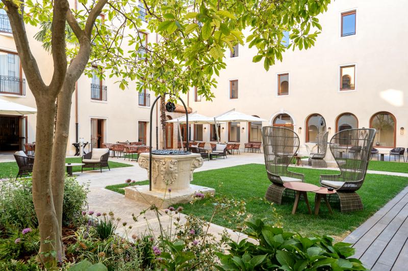 Courtyard at Ca’ di Dio, Venice, with lawn chairs and a tree